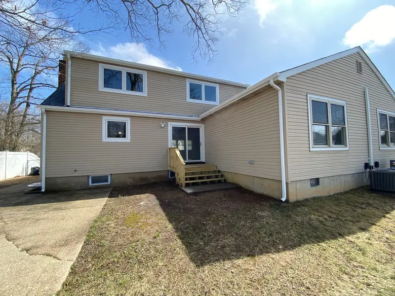 Back of a renovated two-story house with new siding, Massapequa, NY
