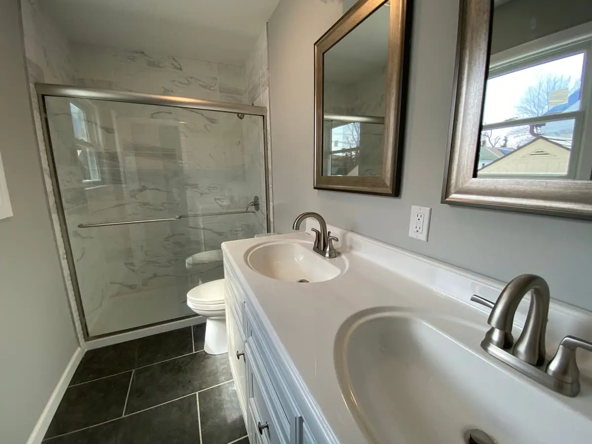 Selling a house after a life change in Massapequa: renovated bathroom with a glass shower and white vanity